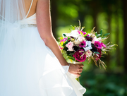 Bride holding a colorful bouquet with a blurred green background